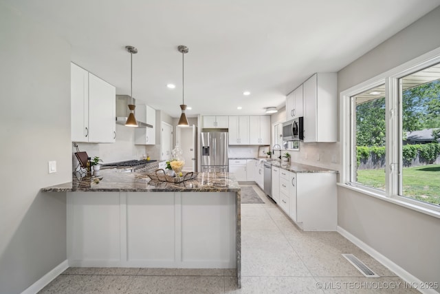 4031 S Birmingham Ave, Tulsa, OK 74105 - kitchen featuring appliances with stainless steel finishes, wall chimney exhaust hood, baseboards, a sink, and dark stone counters