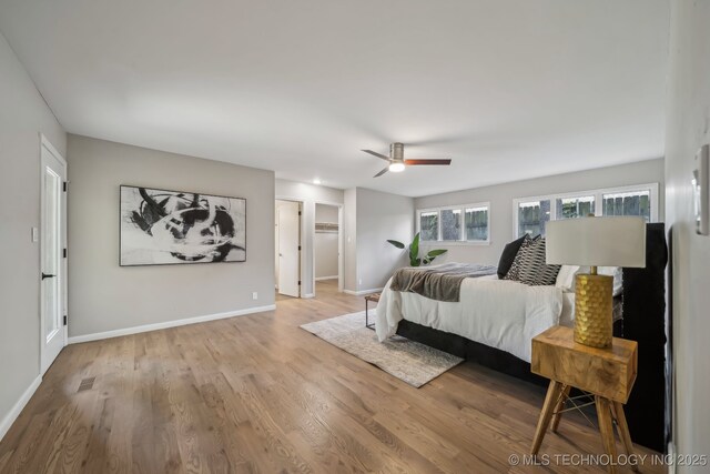 4031 S Birmingham Ave, Tulsa, OK 74105 - bedroom featuring wood finished floors, baseboards, ceiling fan, and a spacious closet