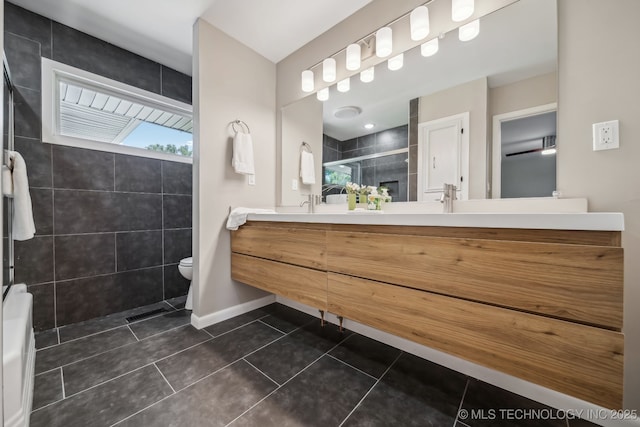 4031 S Birmingham Ave, Tulsa, OK 74105 - bathroom featuring a tile shower, tile patterned flooring, double vanity, toilet, and baseboards