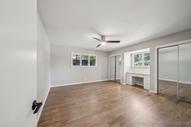4031 S Birmingham Ave, Tulsa, OK 74105 - unfurnished bedroom featuring multiple windows, two closets, and baseboards