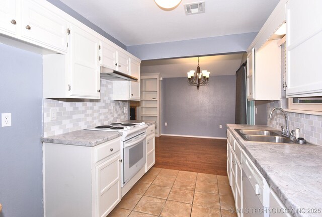 kitchen featuring electric stove, a sink, white cabinets, a chandelier, and under cabinet range hood