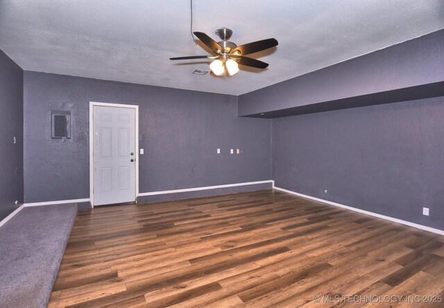 spare room featuring ceiling fan, wood finished floors, baseboards, and a textured ceiling