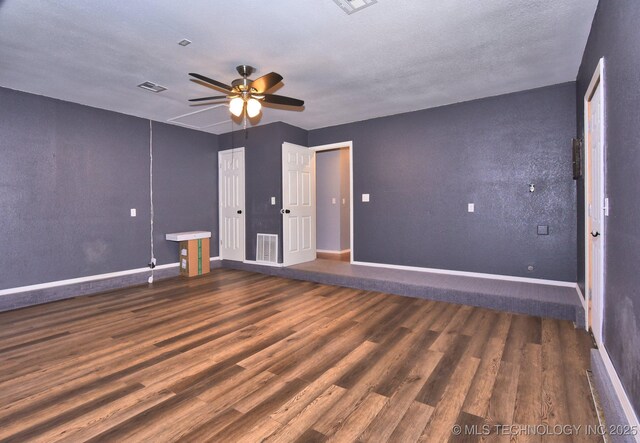 empty room featuring wood finished floors, ceiling fan, and baseboards