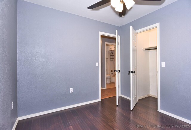 unfurnished bedroom with wood finished floors, baseboards, ceiling fan, and a closet