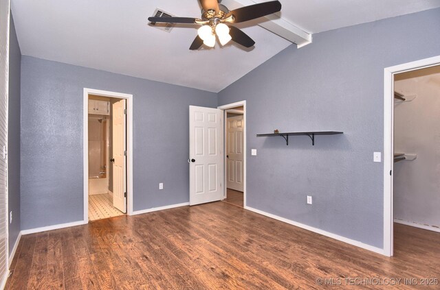 unfurnished bedroom featuring a spacious closet, wood finished floors, baseboards, and a closet