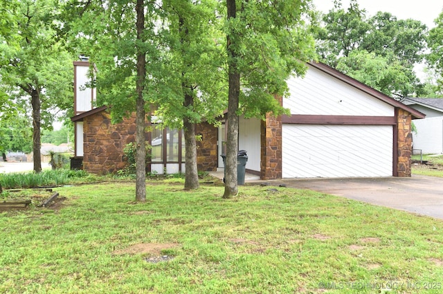 view of front of house with stone siding, asphalt driveway, a front lawn, and a garage