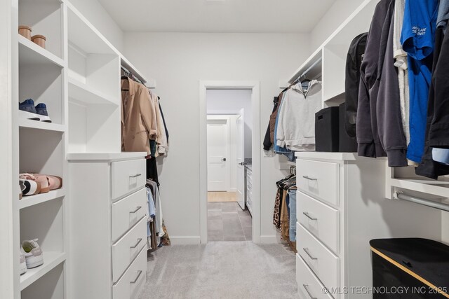 walk in closet featuring light colored carpet