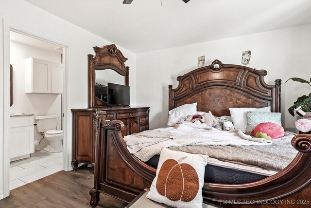 bedroom featuring dark wood-style flooring, ensuite bath, and a ceiling fan