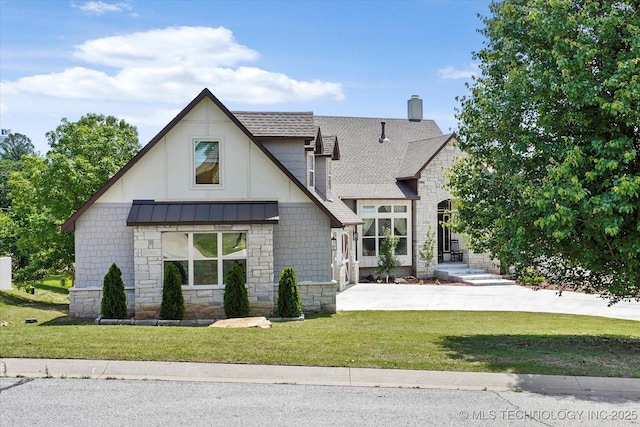 view of front of home featuring stone siding, a shingled roof, a front yard, and a chimney