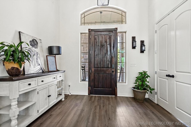 entryway featuring dark wood-type flooring and baseboards
