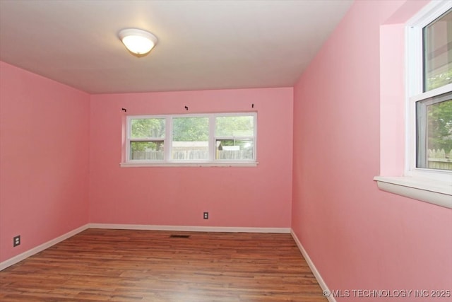 spare room featuring wood finished floors and baseboards