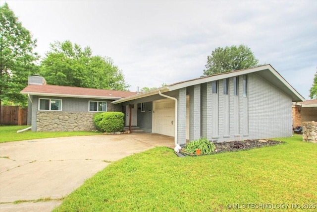 ranch-style home with a garage, a chimney, stone siding, driveway, and a front lawn
