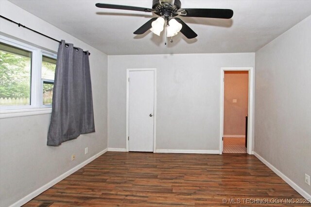 unfurnished bedroom with wood finished floors, baseboards, and a ceiling fan