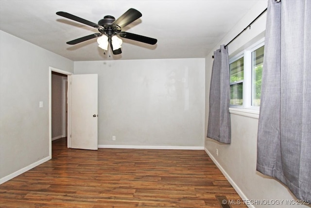 empty room featuring wood finished floors, baseboards, and ceiling fan