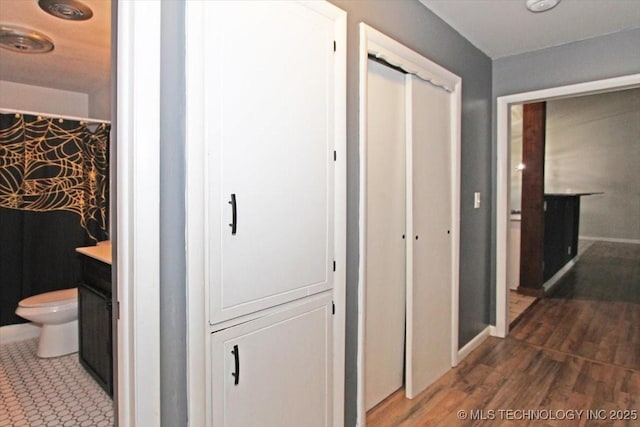 corridor with wood finished floors and baseboards