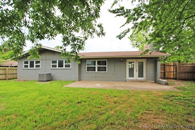 back of house with central AC unit, french doors, a patio, and brick siding