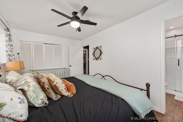 bedroom with wood finished floors, a closet, baseboards, ensuite bath, and recessed lighting