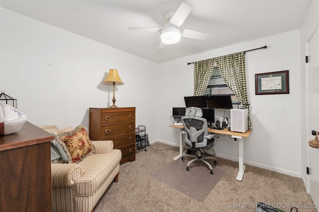 carpeted office featuring a ceiling fan and baseboards