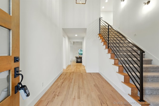 entryway with wood finished floors, stairs, recessed lighting, and baseboards