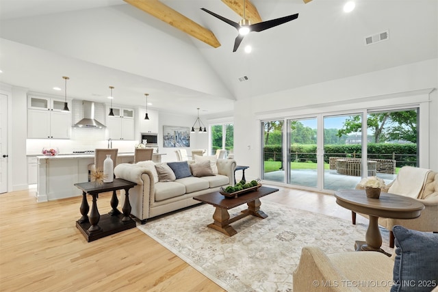 living room featuring recessed lighting, light wood finished floors, high vaulted ceiling, a ceiling fan, and beam ceiling