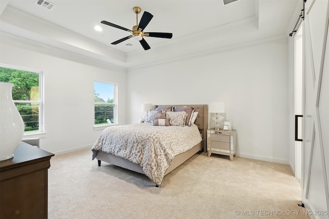 bedroom featuring a raised ceiling, light colored carpet, crown molding, a barn door, and baseboards