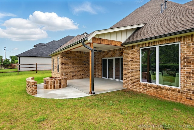 rear view of house with ceiling fan, brick siding, roof with shingles, and a patio