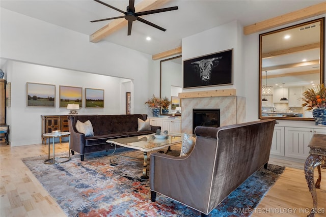 6038 E 119th Pl, Tulsa, OK 74137 - living area featuring beam ceiling, ceiling fan, light wood-style floors, a fireplace, and recessed lighting
