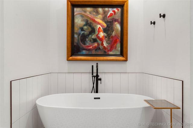 6038 E 119th Pl, Tulsa, OK 74137 - full bathroom featuring a soaking tub, a wainscoted wall, and a decorative wall
