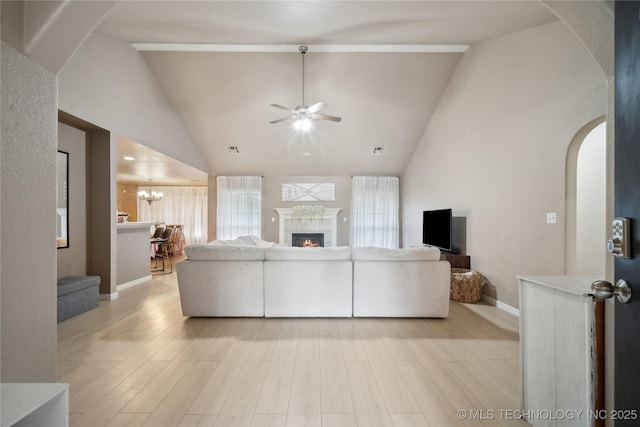 1905 Walnut Hill Ln, Claremore, OK 74019 - living area featuring arched walkways, ceiling fan, a tile fireplace, light wood-style flooring, and baseboards