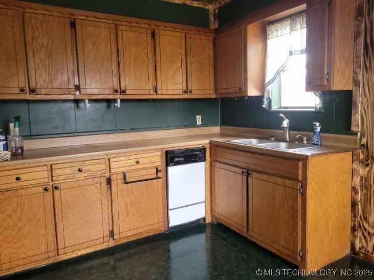 409 W Arkansas, Durant, OK 74701 - kitchen with dishwasher, light countertops, a sink, and brown cabinets