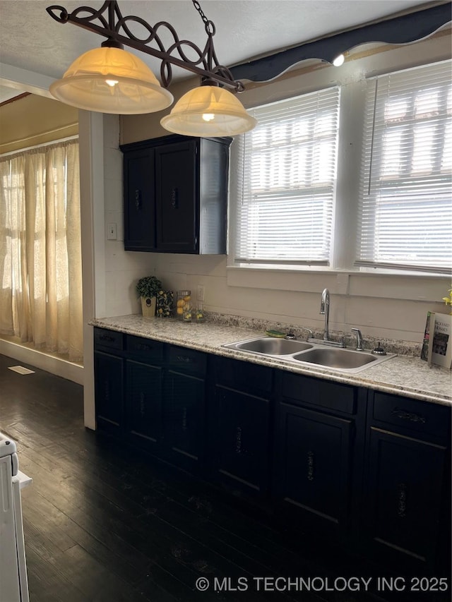 918 W Cedar St, Durant, OK 74701 - kitchen with a sink, dark cabinets, dark wood-style floors, and healthy amount of natural light
