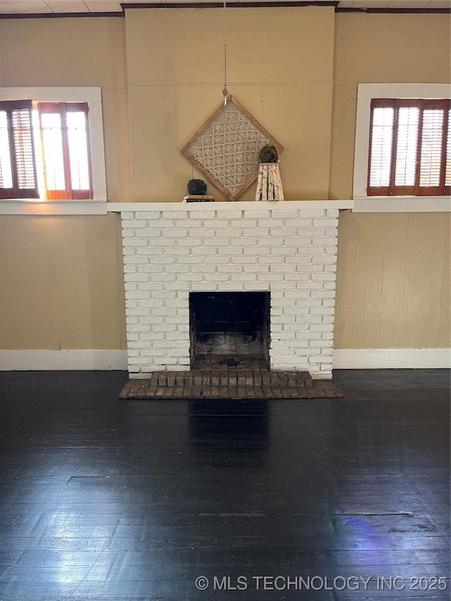 918 W Cedar St, Durant, OK 74701 - unfurnished living room featuring hardwood / wood-style floors, baseboards, and a brick fireplace