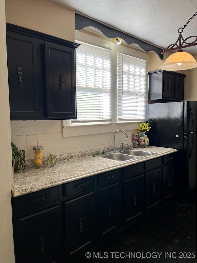 918 W Cedar St, Durant, OK 74701 - kitchen featuring a sink, dark cabinetry, light countertops, and wood finished floors