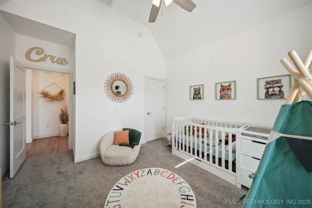 carpeted bedroom featuring a crib, high vaulted ceiling, and a ceiling fan