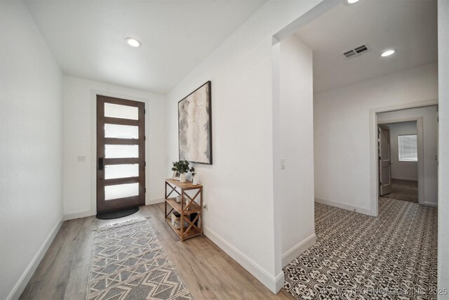 entrance foyer featuring baseboards, light wood finished floors, and recessed lighting
