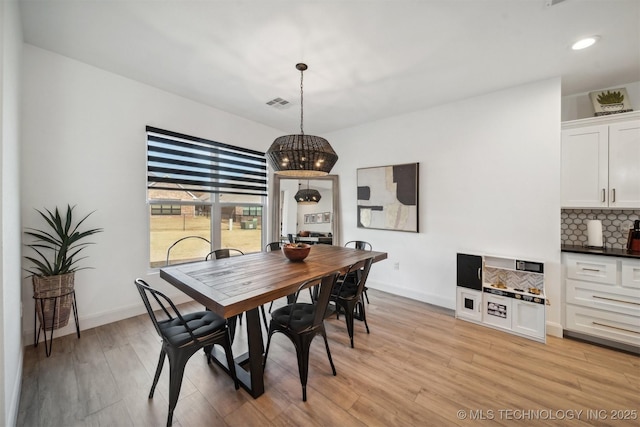 dining room with light wood-style floors, baseboards, and recessed lighting