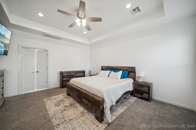 carpeted bedroom featuring a raised ceiling, baseboards, recessed lighting, and ceiling fan