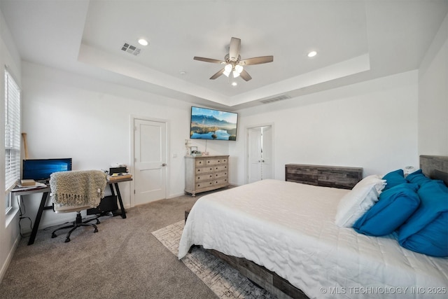 carpeted bedroom featuring a tray ceiling, a desk, recessed lighting, baseboards, and ceiling fan