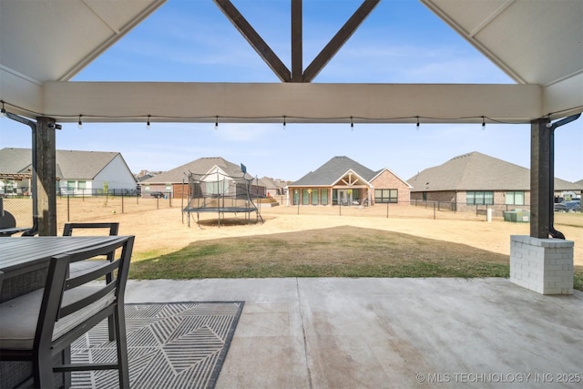 view of patio / terrace with a trampoline, a residential view, and outdoor dining space