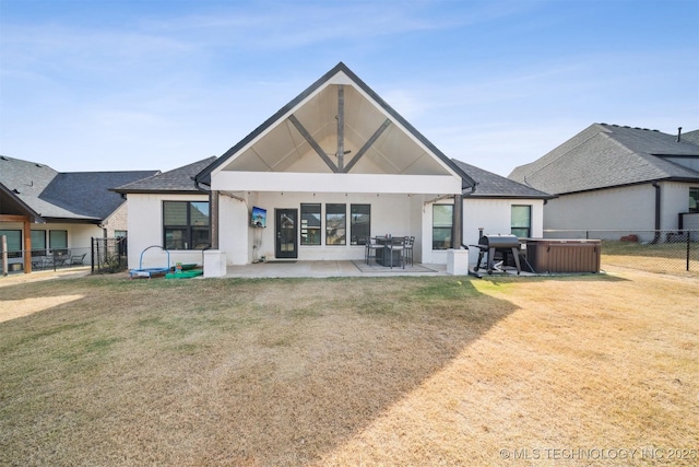 back of property with stucco siding, a patio area, and roof with shingles