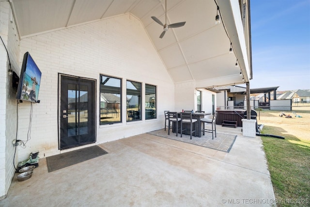 view of patio / terrace featuring a hot tub, ceiling fan, and fence