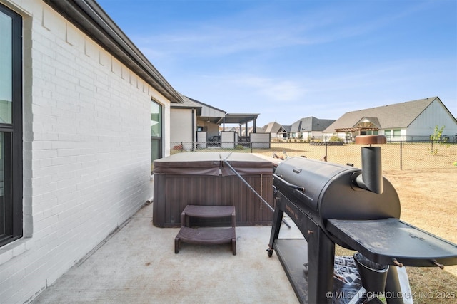 view of patio / terrace with a hot tub, a fenced backyard, and a residential view