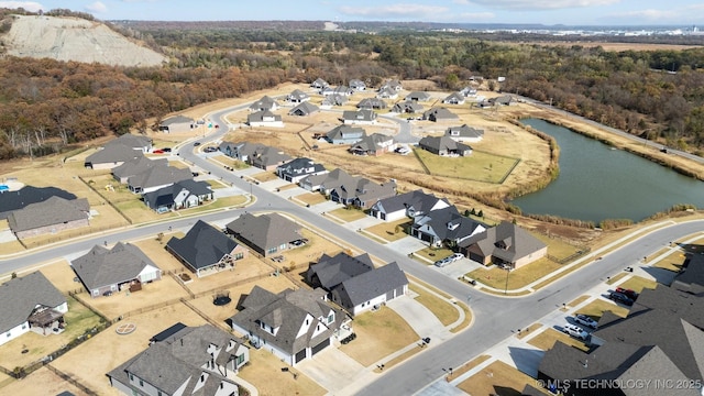 aerial view of property's location with a heavily wooded area, a nearby body of water, and nearby suburban area
