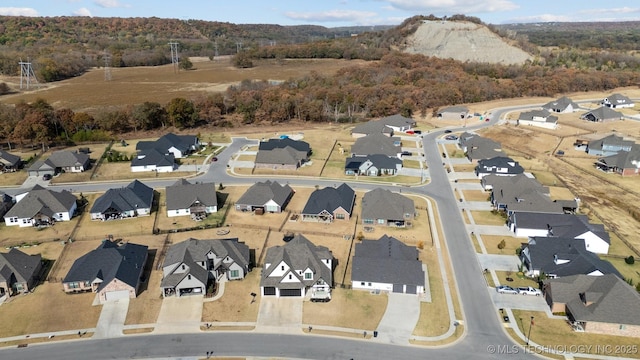 aerial view of property and surrounding area featuring nearby suburban area and a forest