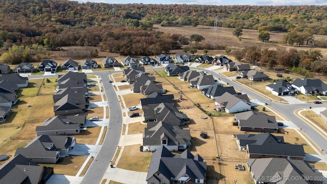 view of property location with a heavily wooded area and nearby suburban area