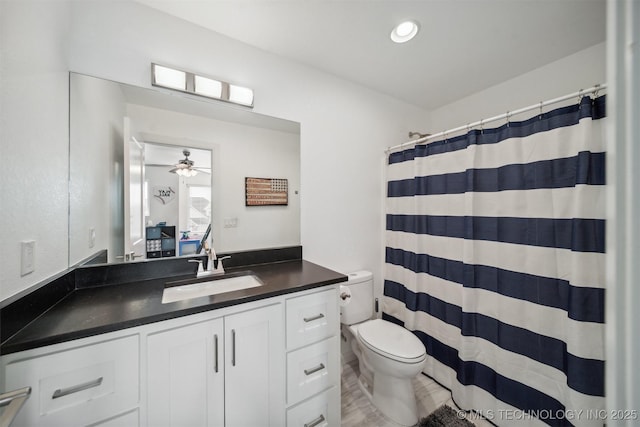 full bathroom featuring toilet, vanity, curtained shower, and a ceiling fan