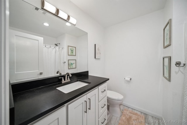 full bath with toilet, baseboards, and vanity