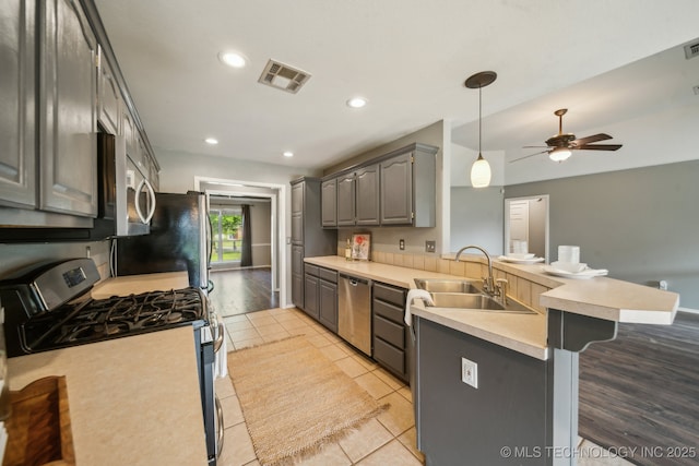 4719 S 194th E Ave, Broken Arrow, OK 74014 - kitchen with stainless steel appliances, a sink, a peninsula, gray cabinetry, and ceiling fan