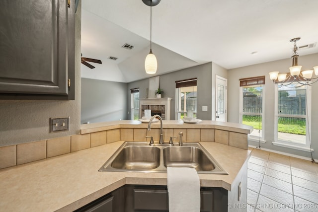 4719 S 194th E Ave, Broken Arrow, OK 74014 - kitchen with a sink, light countertops, a brick fireplace, light tile patterned floors, and vaulted ceiling