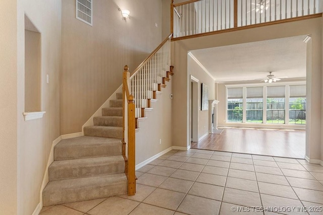 8531 S 70th E Ave, Tulsa, OK 74133 - staircase with tile patterned floors, a ceiling fan, baseboards, and crown molding